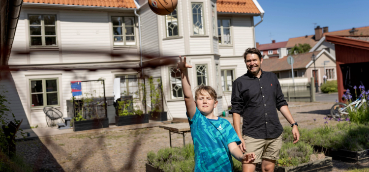 Man och pojke framför ett hus