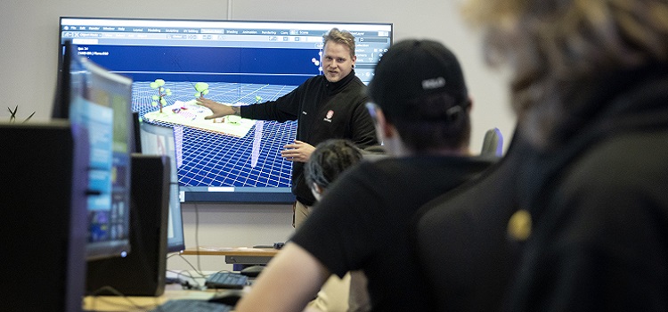 Person pratar framför en bildskärm